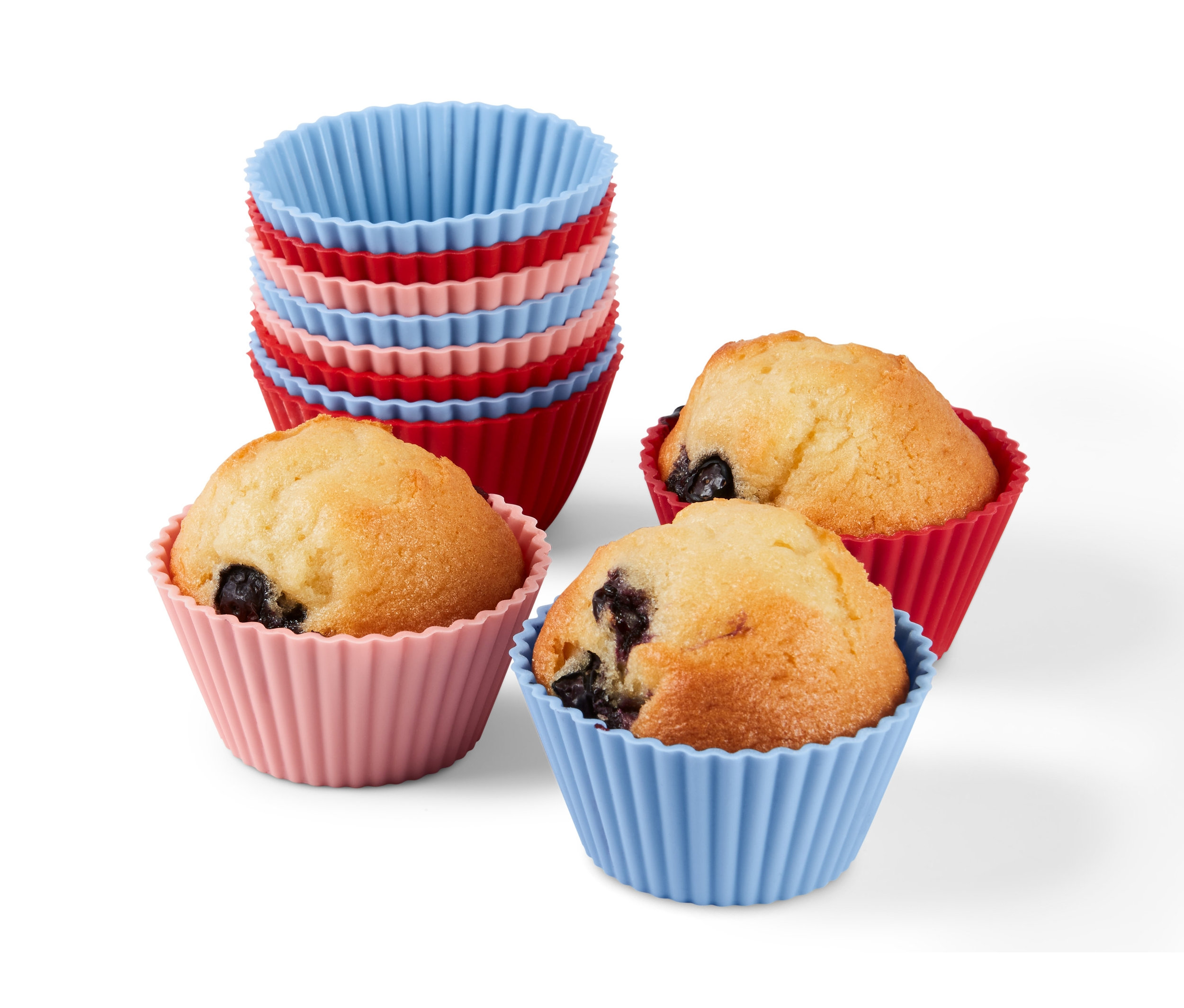 Trzy babeczki w czerwonych, różowych i niebieskich foremkach do muffinów (12 sztuk) oraz stos foremek.
