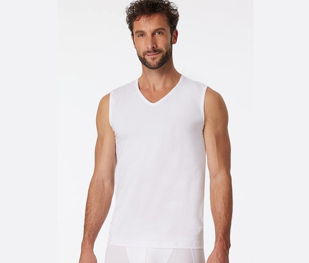 Mężczyzna ma na sobie białą podkoszulkę typu tanktop z bawełny ekologicznej SCHIESSER.