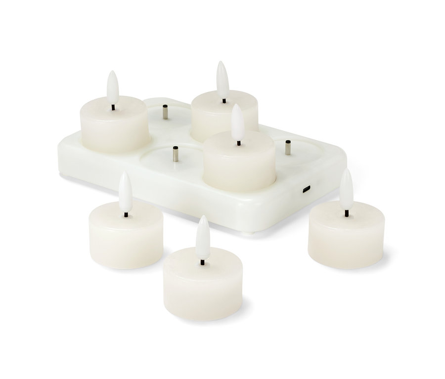 Sześć świec LED z prawdziwego wosku z akumulatorem stoi na białej stacji ładującej.