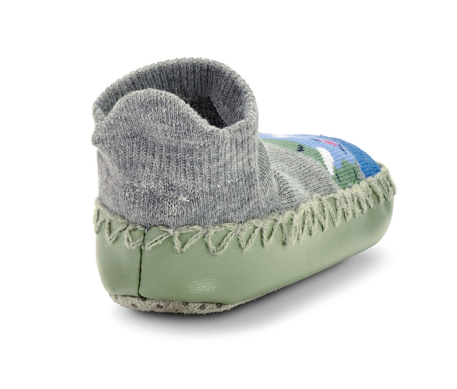 Zbliżenie na skarpeto-kapcie dziecięce z szarą, dzianinową górą i zieloną podeszwą.