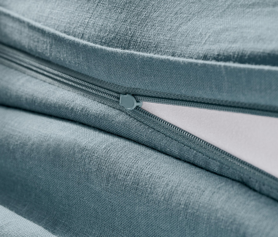 Zbliżenie na niebieską lnianą poszewkę na kołdrę z zamkiem błyskawicznym.
