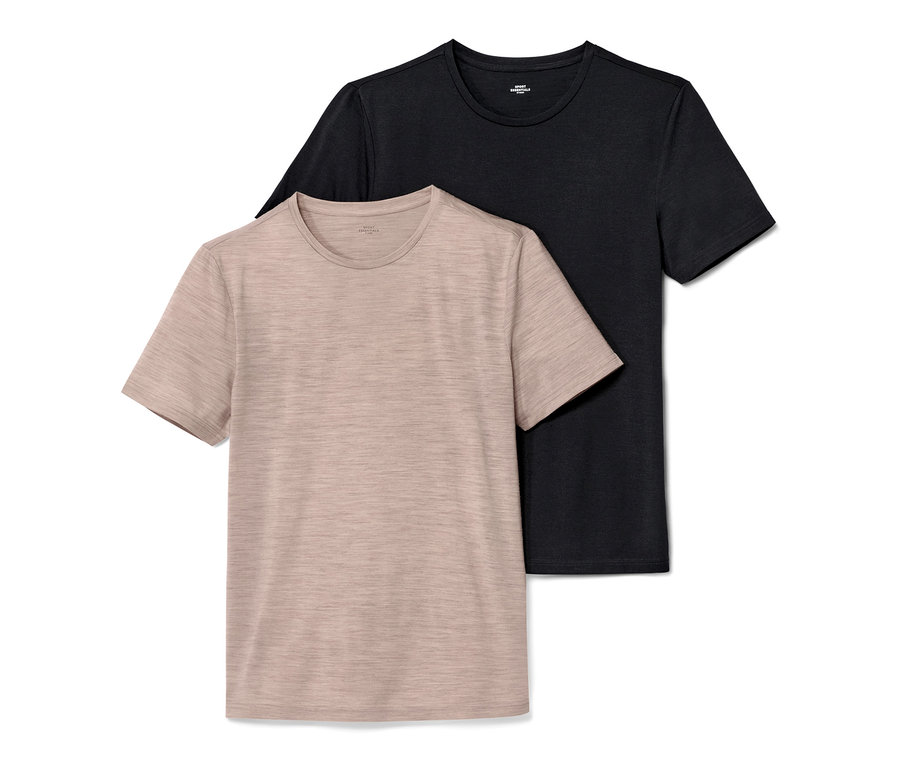 Dwa t-shirty z krótkim rękawem: beżowy t-shirt z wełny merino na pierwszym planie i czarny t-shirt w tle.