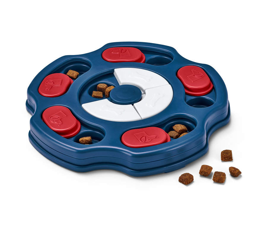 Zabawka interaktywna dla psa z niebieską tacą, czerwonymi suwakami i białymi kośćmi, wypełniona smakołykami.