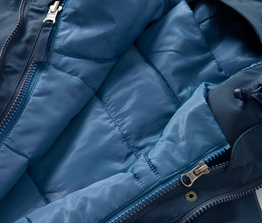 Szczegółowe ujęcie rozpiętego płaszcza funkcyjnego 3 w 1 z kamizelką, wewnętrzna strona kamizelki jest jasnoniebieska.