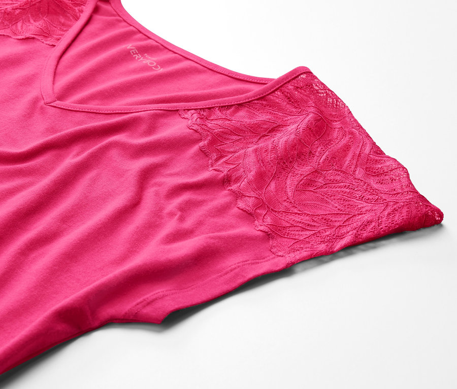 Zbliżenie różowej koszuli nocnej z koronką na białym tle.