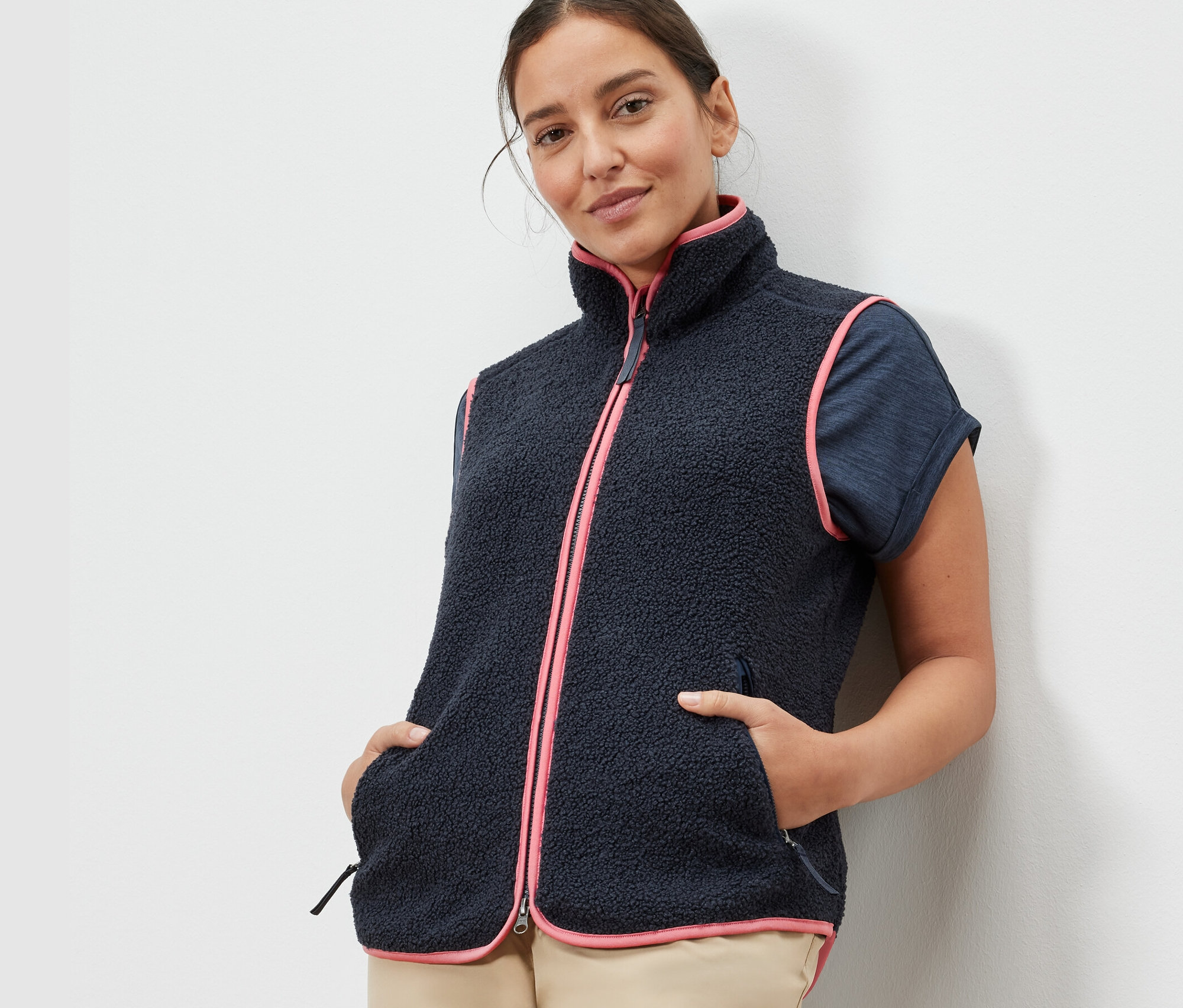 Kobieta ma na sobie kamizelkę z pluszu z różowym wykończeniem.
