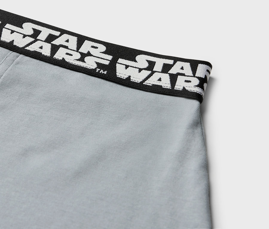 Zbliżenie na szare bokserki z czarnym pasem z białym napisem STAR WARS.