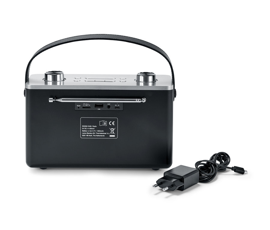 Czarne radio cyfrowe Bluetooth® DAB+/FM i zasilacz leżą obok niego.