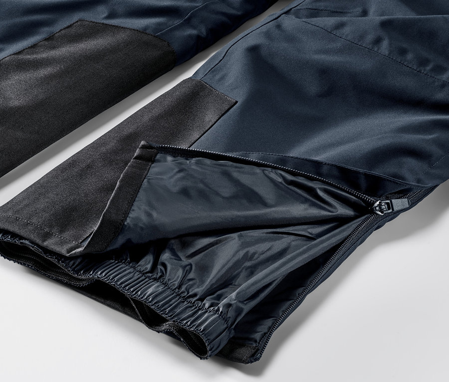 Szczegółowe ujęcie niebieskich, profesjonalnych spodni narciarskich z zamkiem błyskawicznym na nogawce.