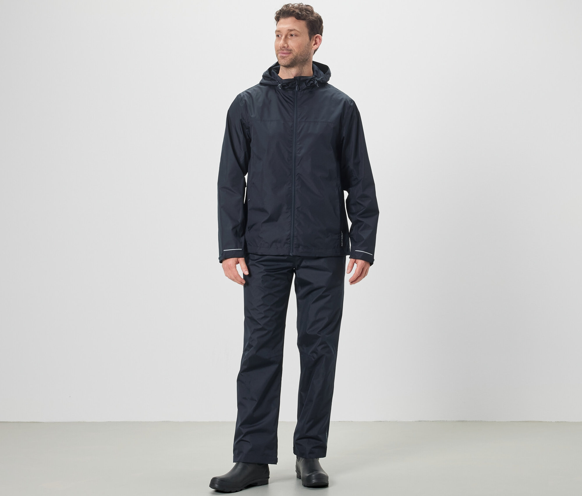 Mężczyzna ma na sobie kurtkę przeciwdeszczową i spodnie przeciwdeszczowe uniseks.