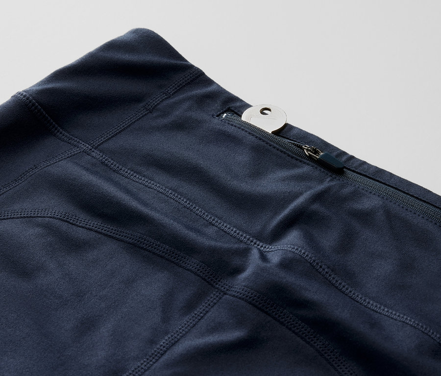 Zbliżenie na legginsy sportowe o długości 3/4 z kluczem w kieszonce na zamek.