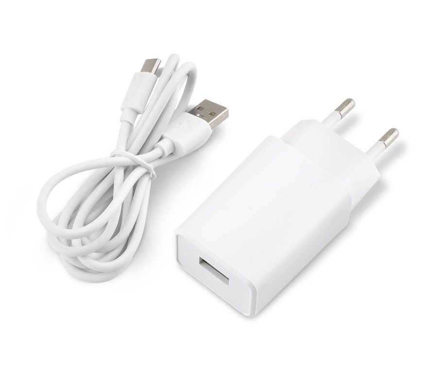 Biały adapter i zwinięty kabel USB leżą na białej powierzchni.