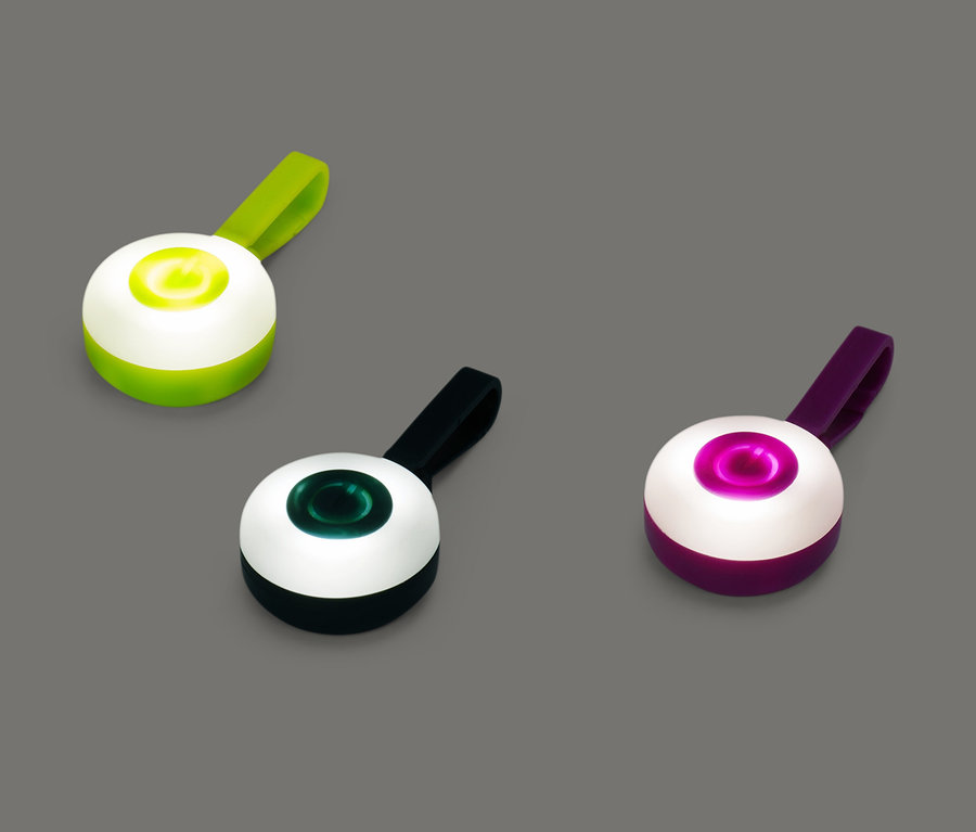Trzy przywieszki LED w różnych kolorach leżą na szarym tle.