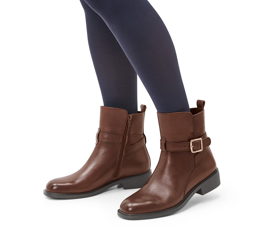 Nogi w granatowych rajstopach w brązowych trzewikach skórzanych.