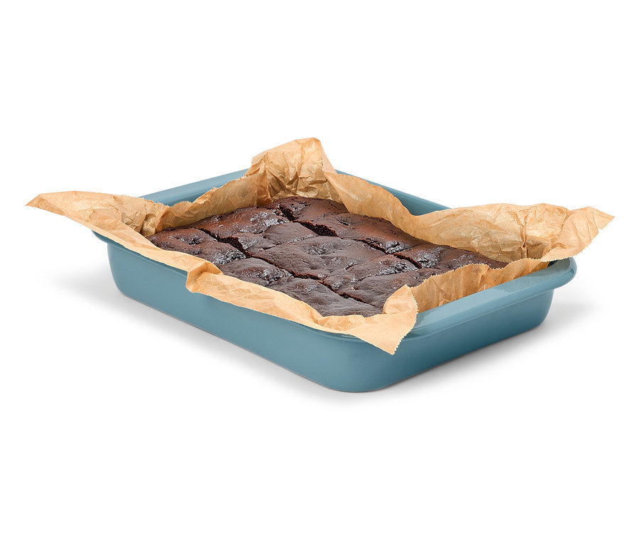 Czekoladowe babeczki brownie w niebieskiej formie do pieczenia z papierem do pieczenia.