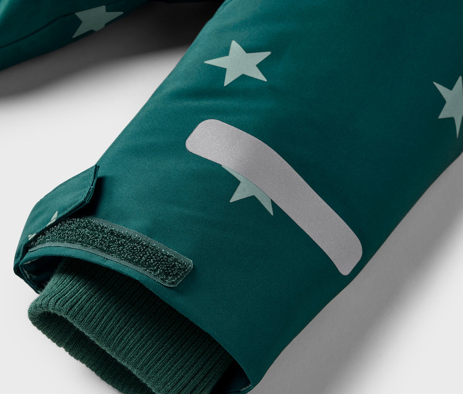 Szczegół rękawa kurtki z gwiazdami i zapięciem na rzep.