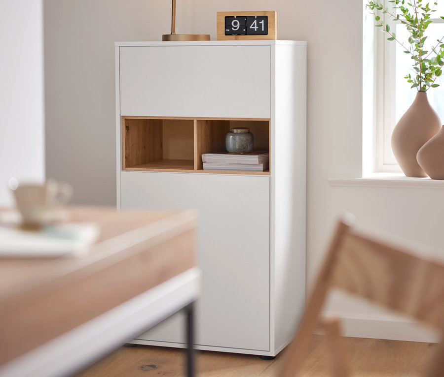Zegar stołowy retro z obracanymi cyframi stoi na szafce typu highboard z detalami z dekoru dębowego obok lampy stołowej »szklana kula«.