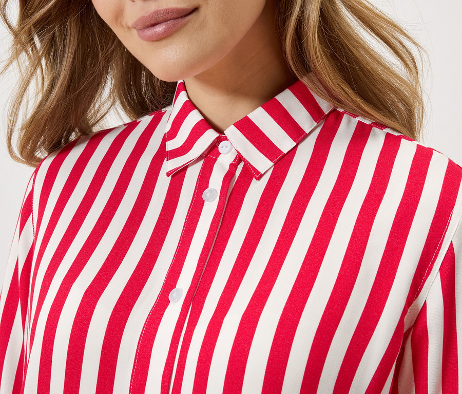 Portret kobiety w czerwono-białej koszuli w paski.