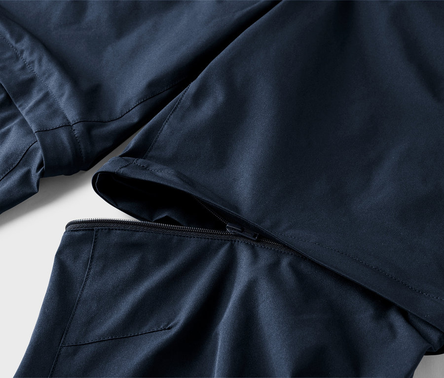 Zbliżenie na granatowe spodnie z odpinaną nogawką.