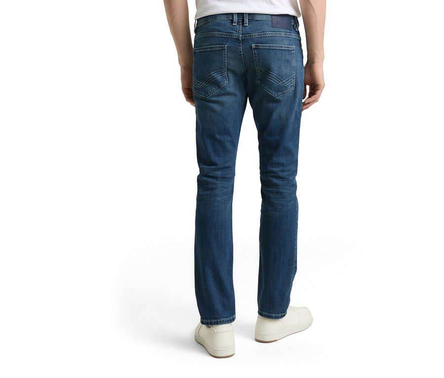 Mężczyzna od tyłu w dżinsach Tom Tailor TT MARVIN STRAIGHT ze stretchem, Used Mid Stone Blue Denim i białych butach.