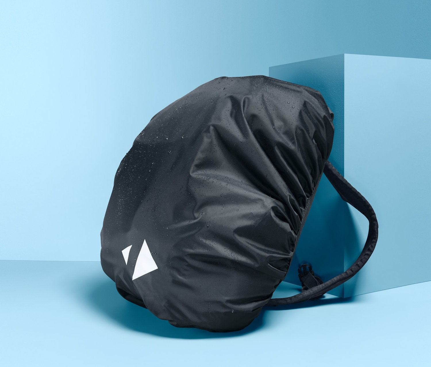 Czarny plecak z osłoną przeciwdeszczową na niebieskim tle.