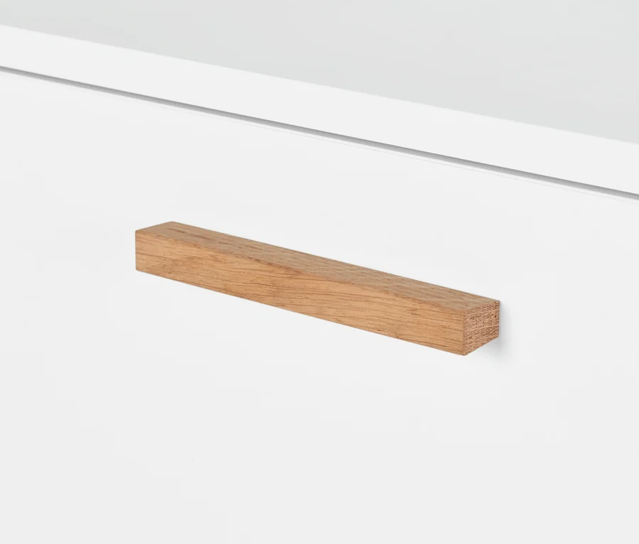 Detal białej szafki typu sideboard „Eklund” z 2 szufladami i drewnianym uchwytem.