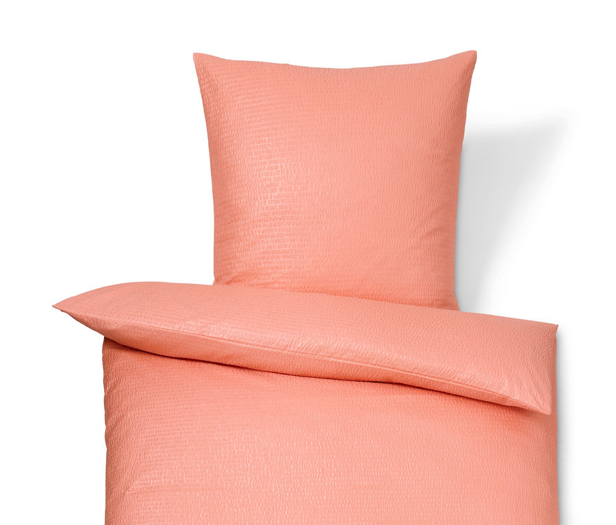 Koralowa pościel z kory w rozmiarze standardowym i niestandardowym leży na białym tle.