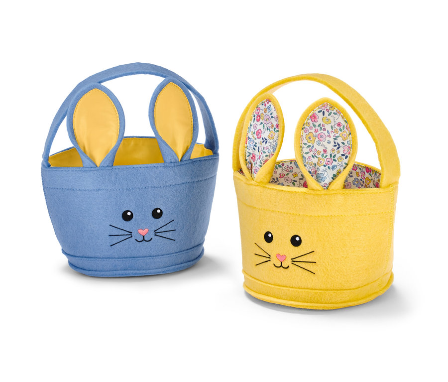 Dwa koszyczki wielkanocne z uszami zająca, jeden niebieski i jeden żółty.