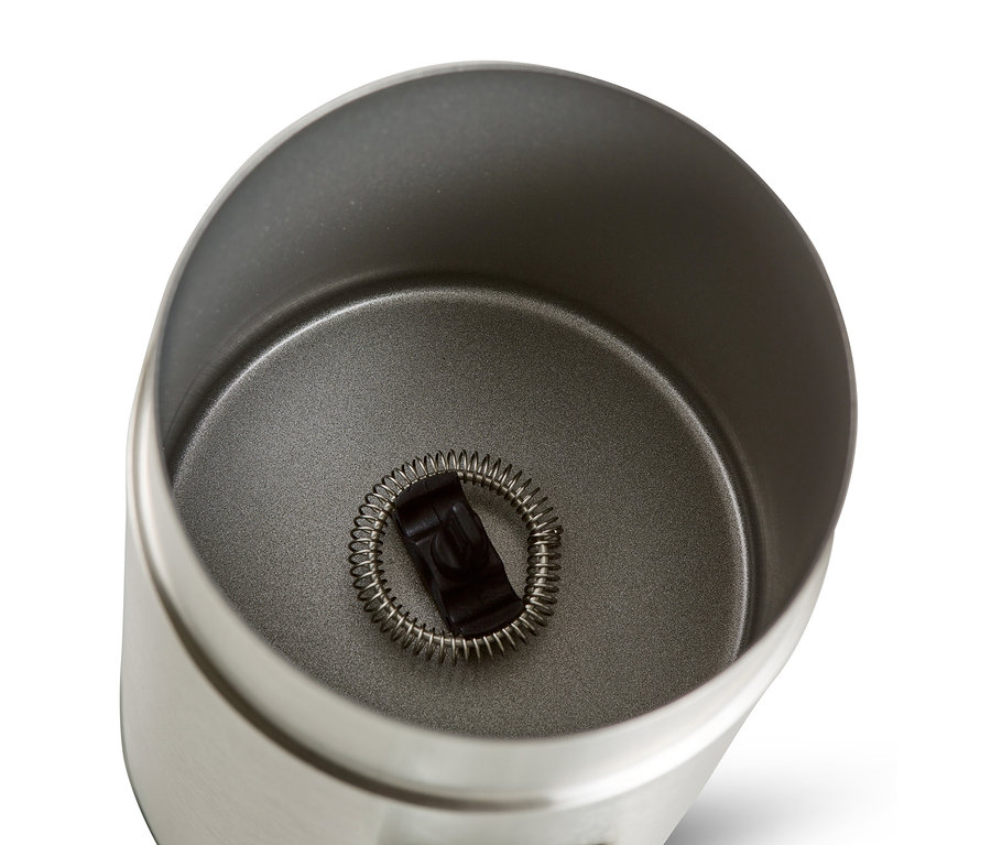 Widok z góry na elektryczny spieniacz do mleka ze stali nierdzewnej z ubijaczką w środku.