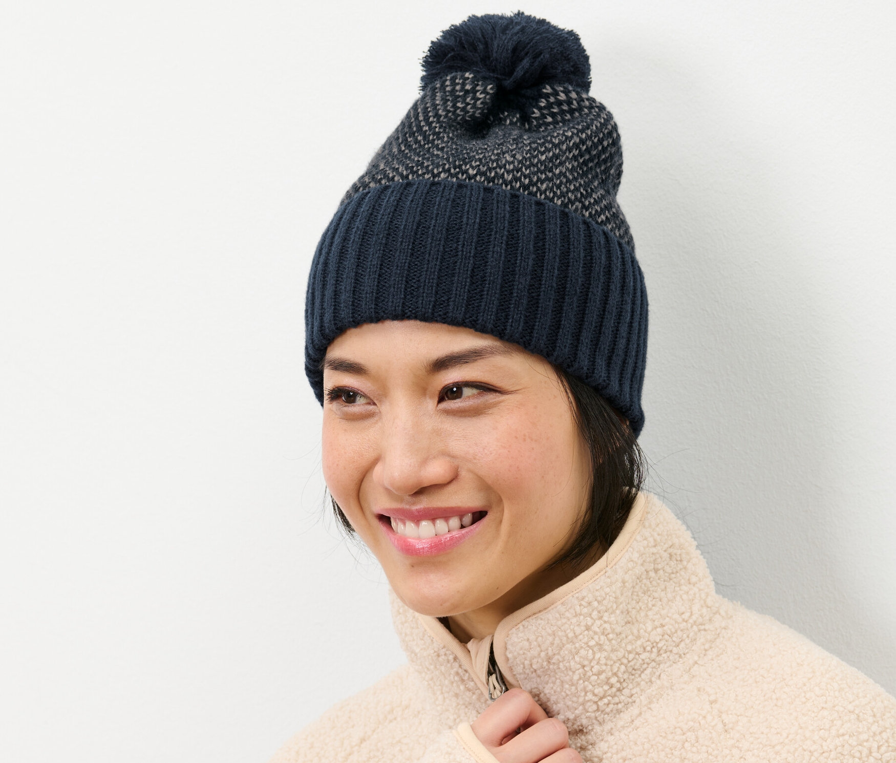 Uśmiechnięta kobieta w czapce z dzianiny.