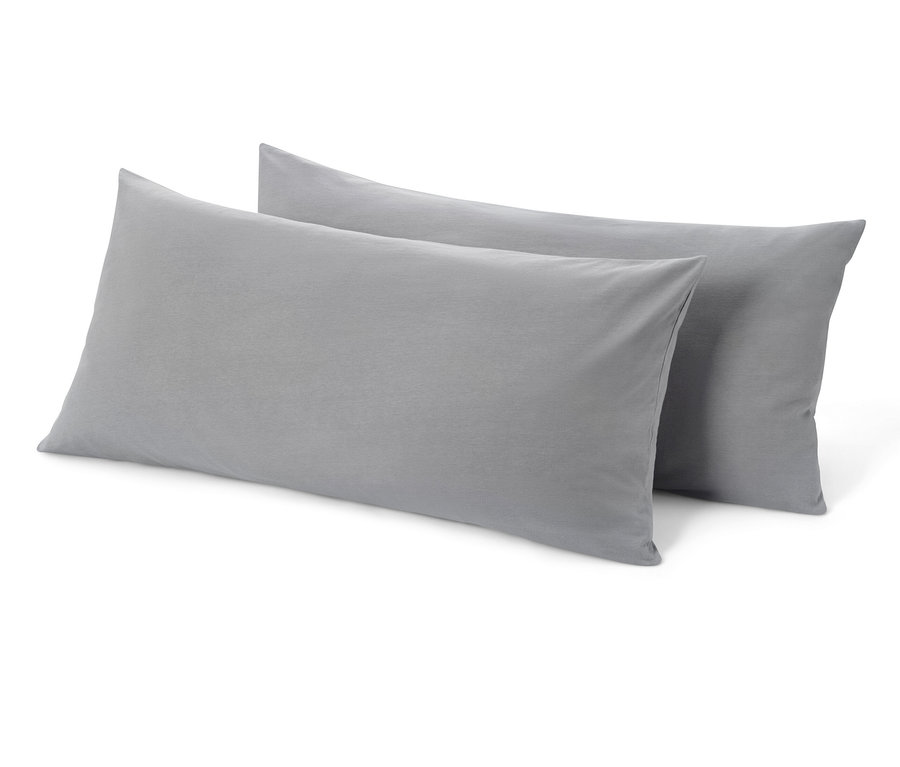 Dwie szare dżersejowe poszewki na poduszki leżą obok siebie.