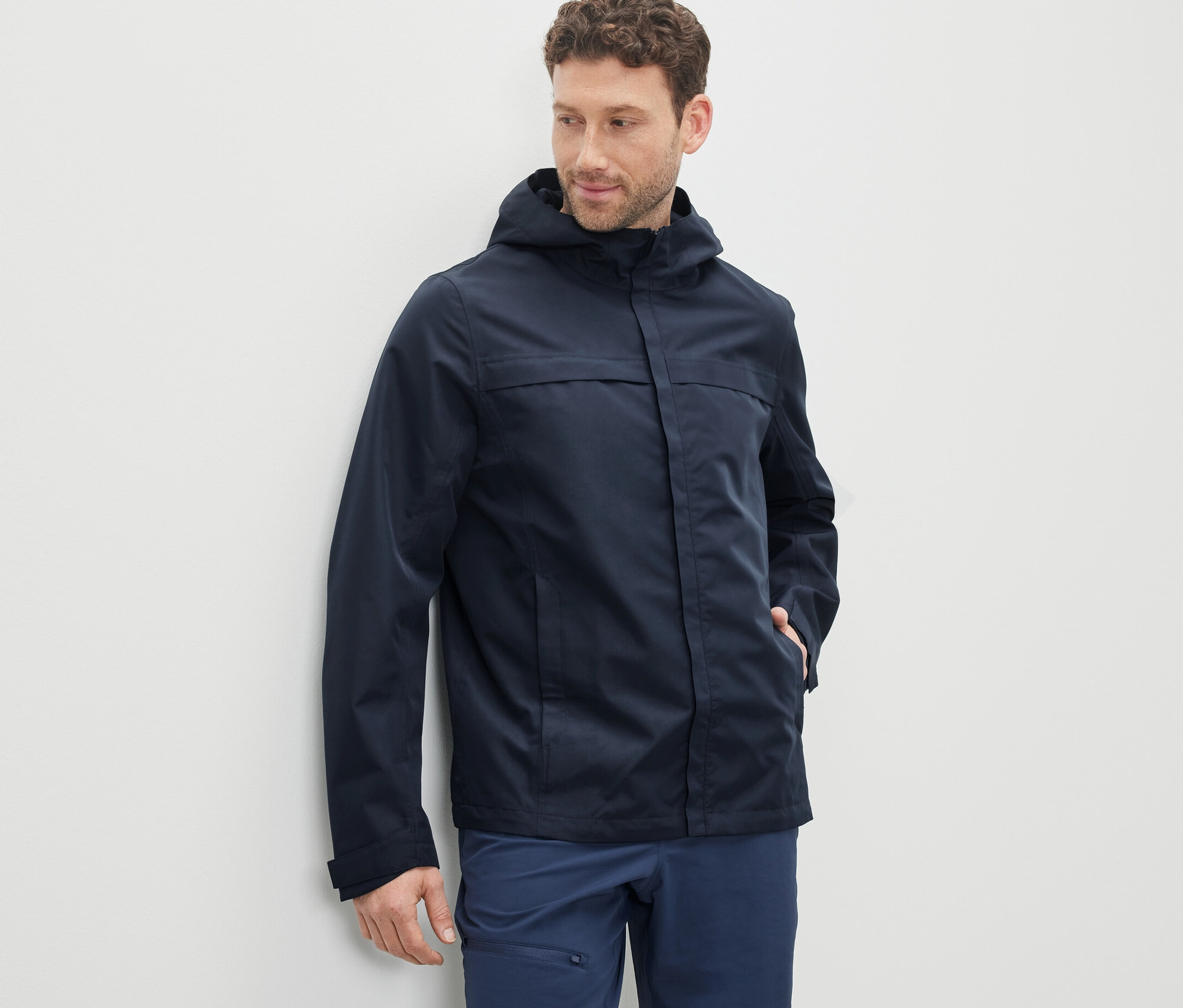 Mężczyzna ma na sobie granatową parkę funkcyjną.