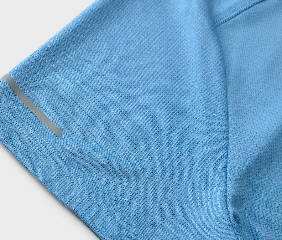 Zbliżenie na jasno niebieską koszulkę sportową z odblaskowym paskiem na rękawie.