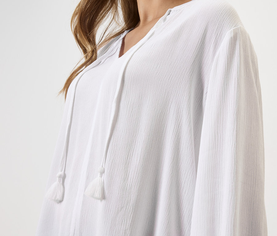 Zbliżenie kobiety w białej bluzce ze sznurkiem.