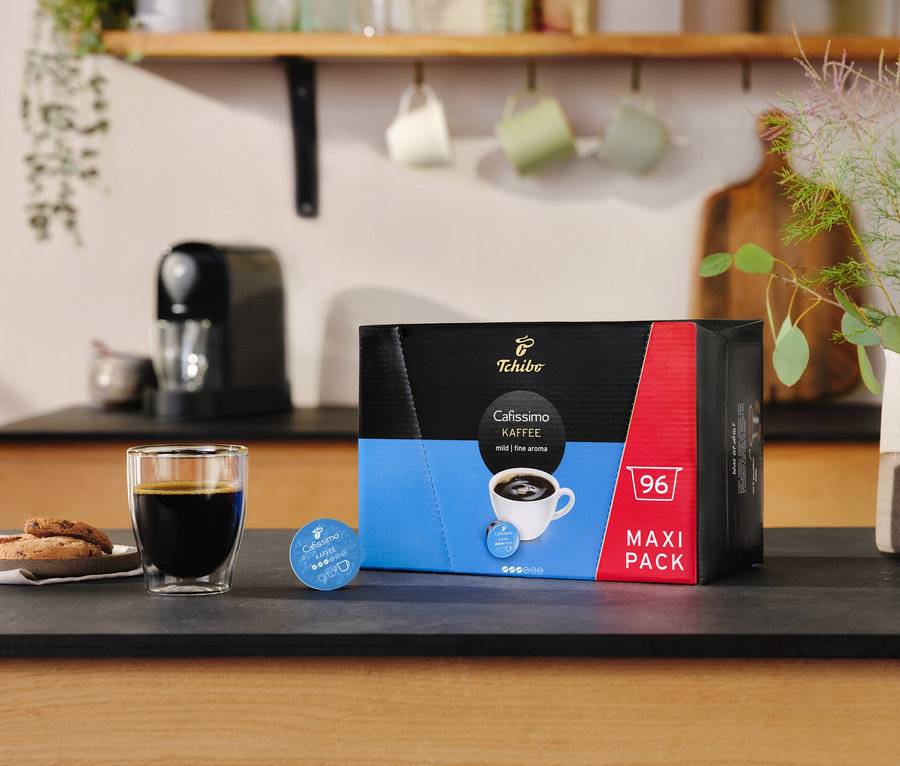 Szklanka kawy i ciasteczka obok opakowania Cafissimo Coffee Intense Aroma - 30 kapsułek.