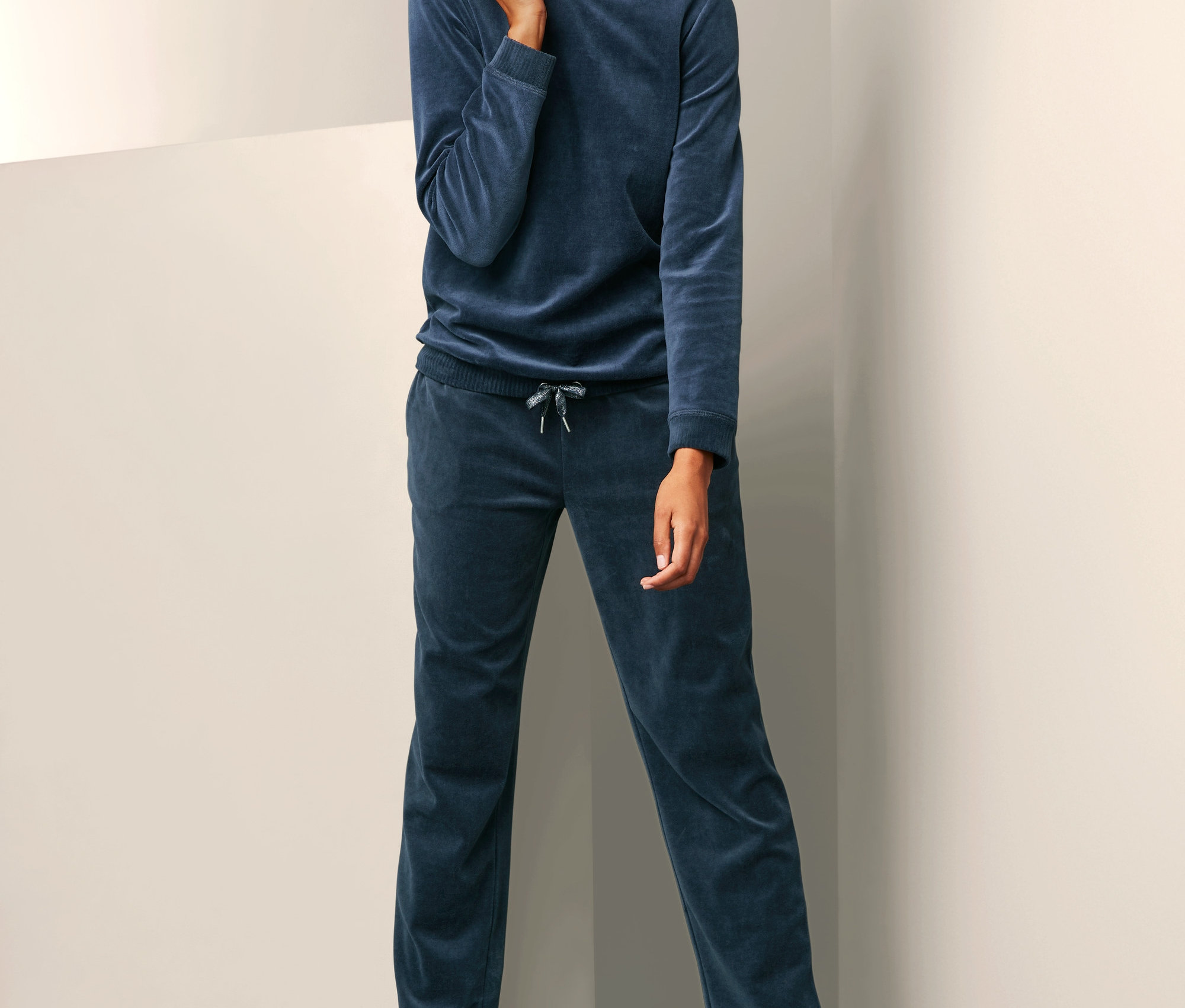 Kobieta pozuje w damskim dresie z weluru z bawełną.