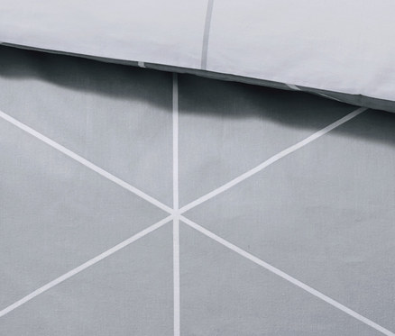 Fragment szarej, dwustronnej pościeli flanelowej z geometrycznym wzorem.