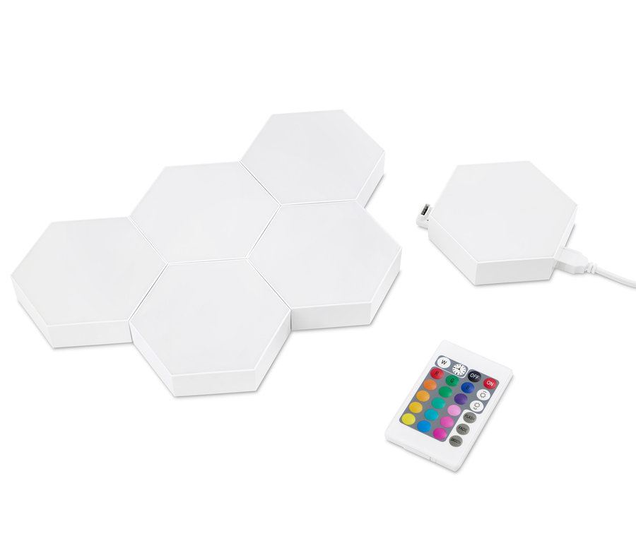 Sześć paneli LED i pilot leżą na białej powierzchni.