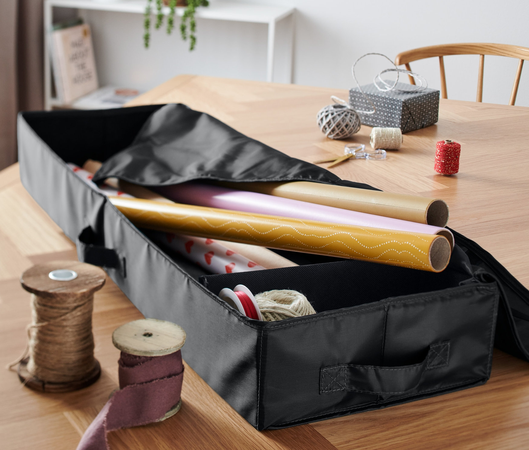 Czarny organizer na papier prezentowy z papierem prezentowym w środku.