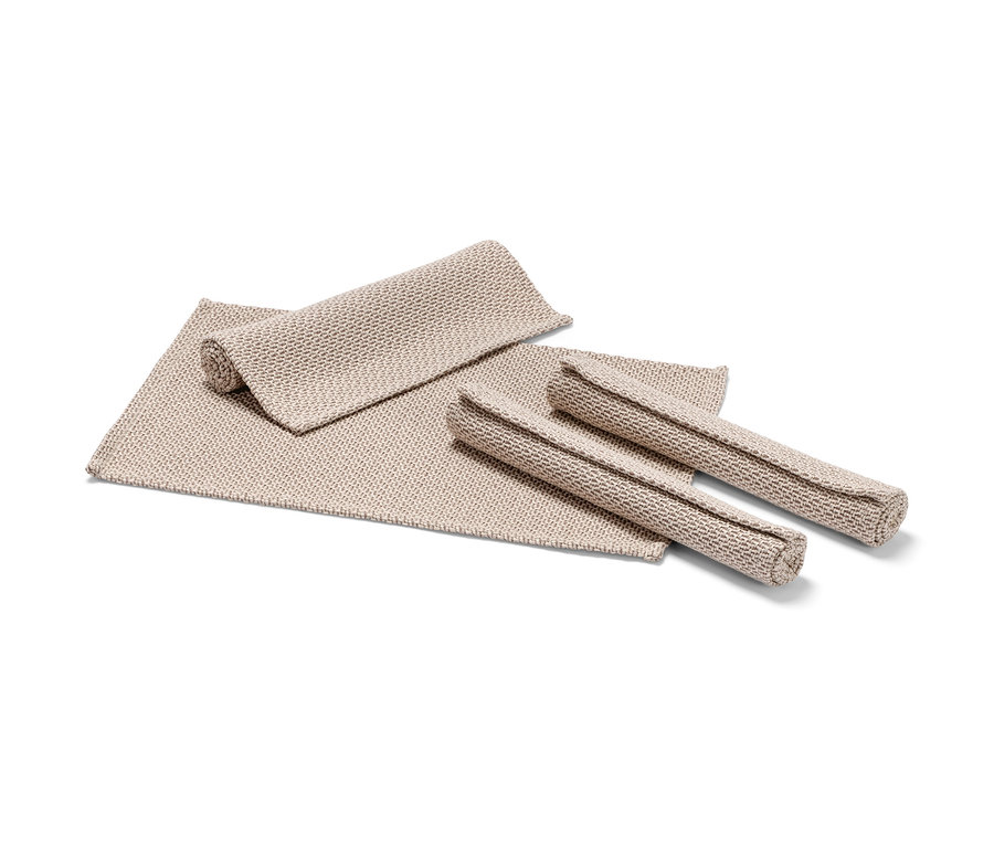 Cztery beżowe podkładki pod talerze.