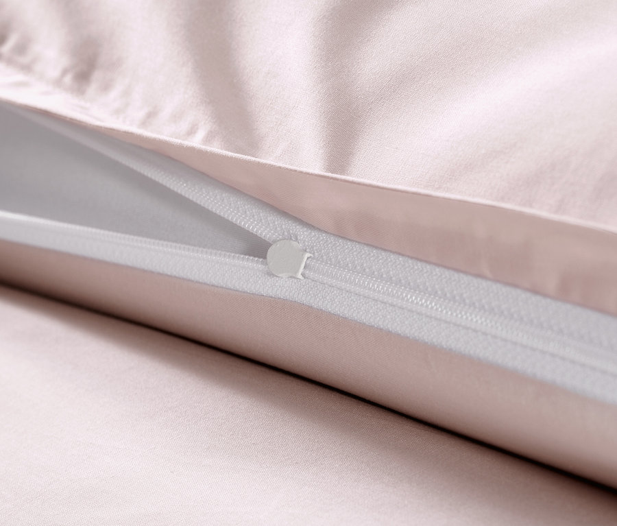Zbliżenie na różową pościel z satyny bawełnianej z zamkiem błyskawicznym.