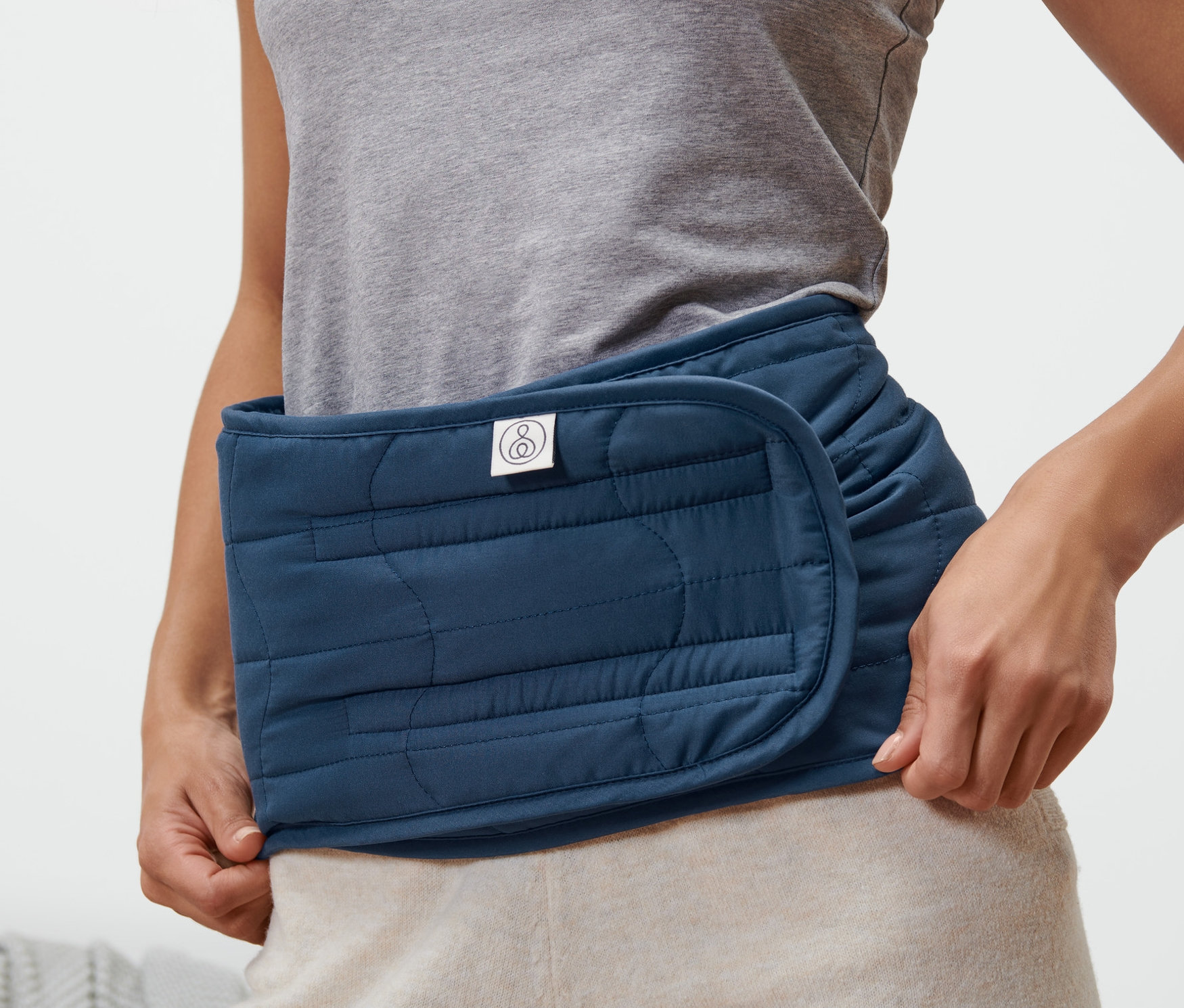 Kobieta nosi ocieplacz na nerki.