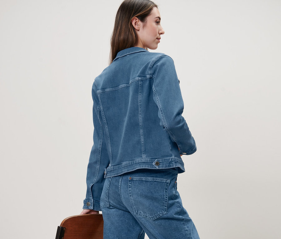 Kobieta z tyłu w kurtce dżinsowej.