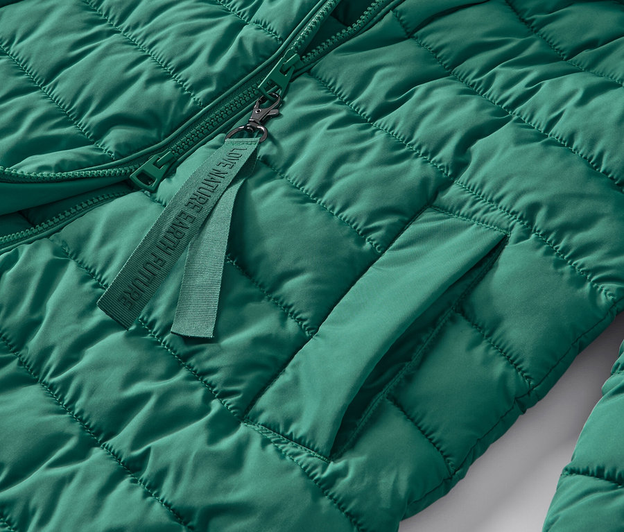 Szczegół zielonego pikowanego płaszcza z kapturem.