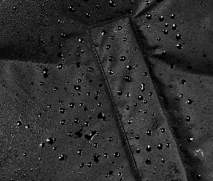 Zbliżenie na zimowy płaszcz przeciwdeszczowy z kroplami wody.