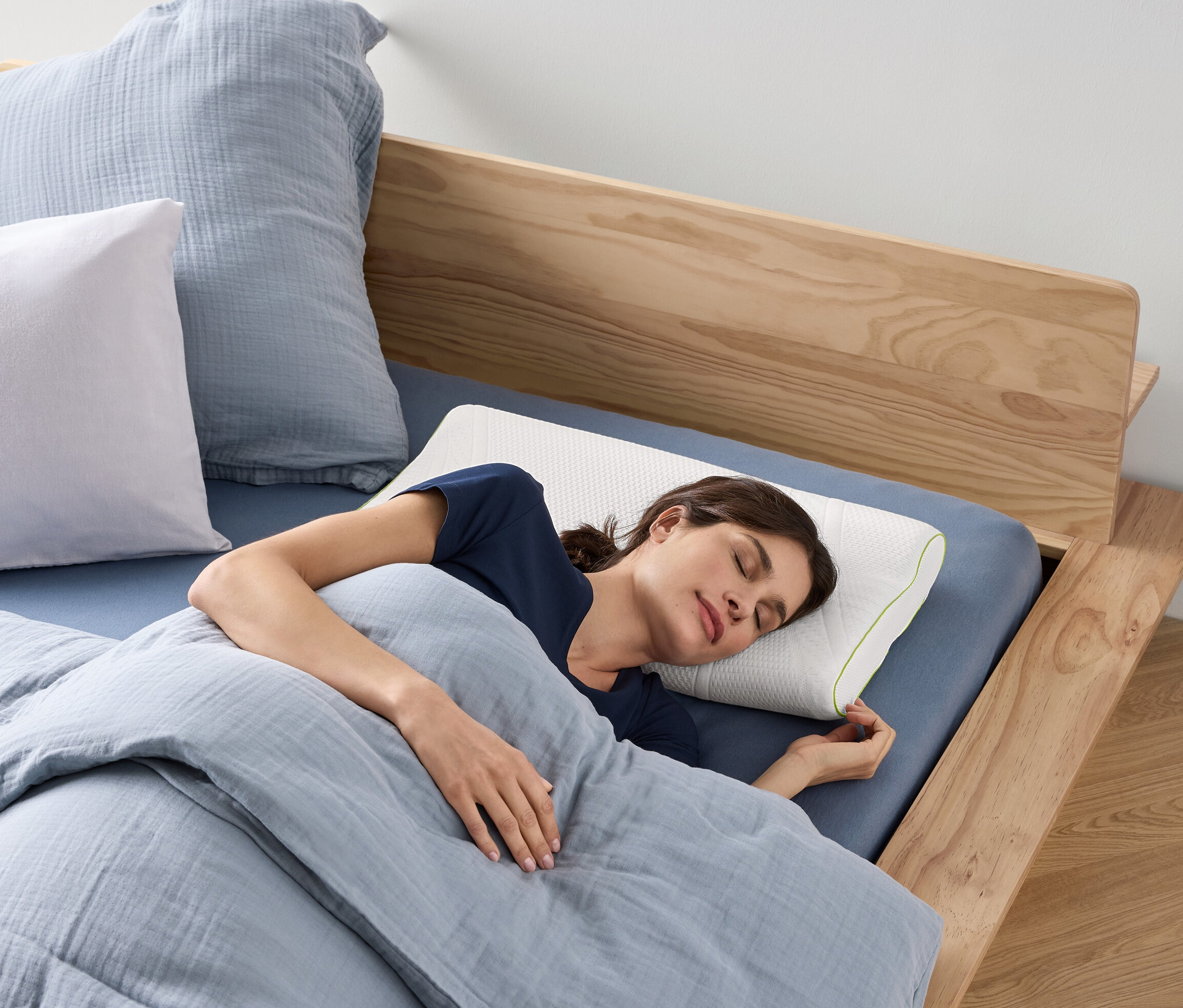 Kobieta śpi na poduszce pod kark irisette® greenline na łóżku.