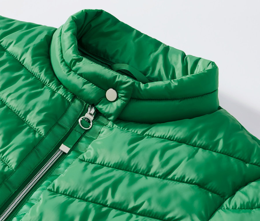 Szczegół zielonej pikowanej kurtki.