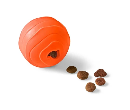 Pomarańczowa zabawka dla psa „Snackball” z otworem, z którego wypadają granulki karmy.