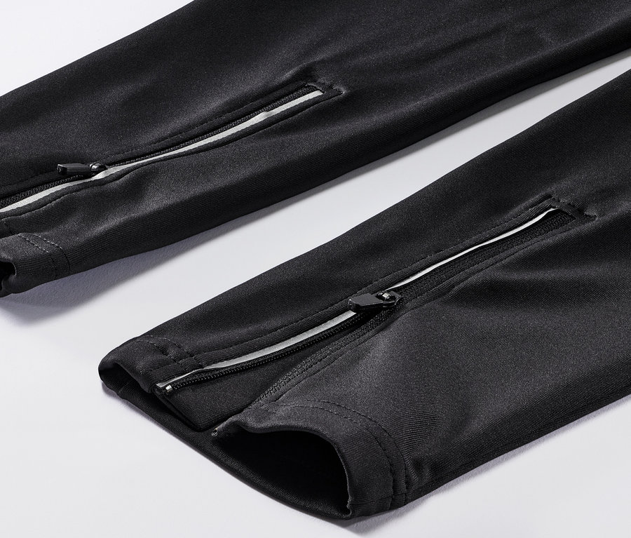 Detal spodni rowerowych z zamkami błyskawicznymi na nogawkach.