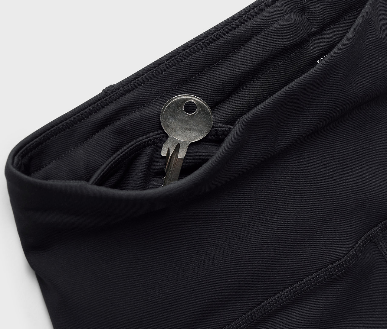 Czarne legginsy z kluczem w kieszeni.